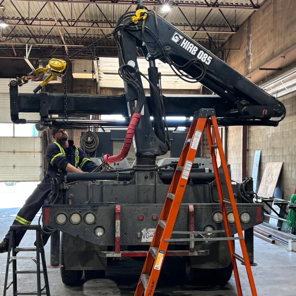 Mechanic working on a truck-mounted crane